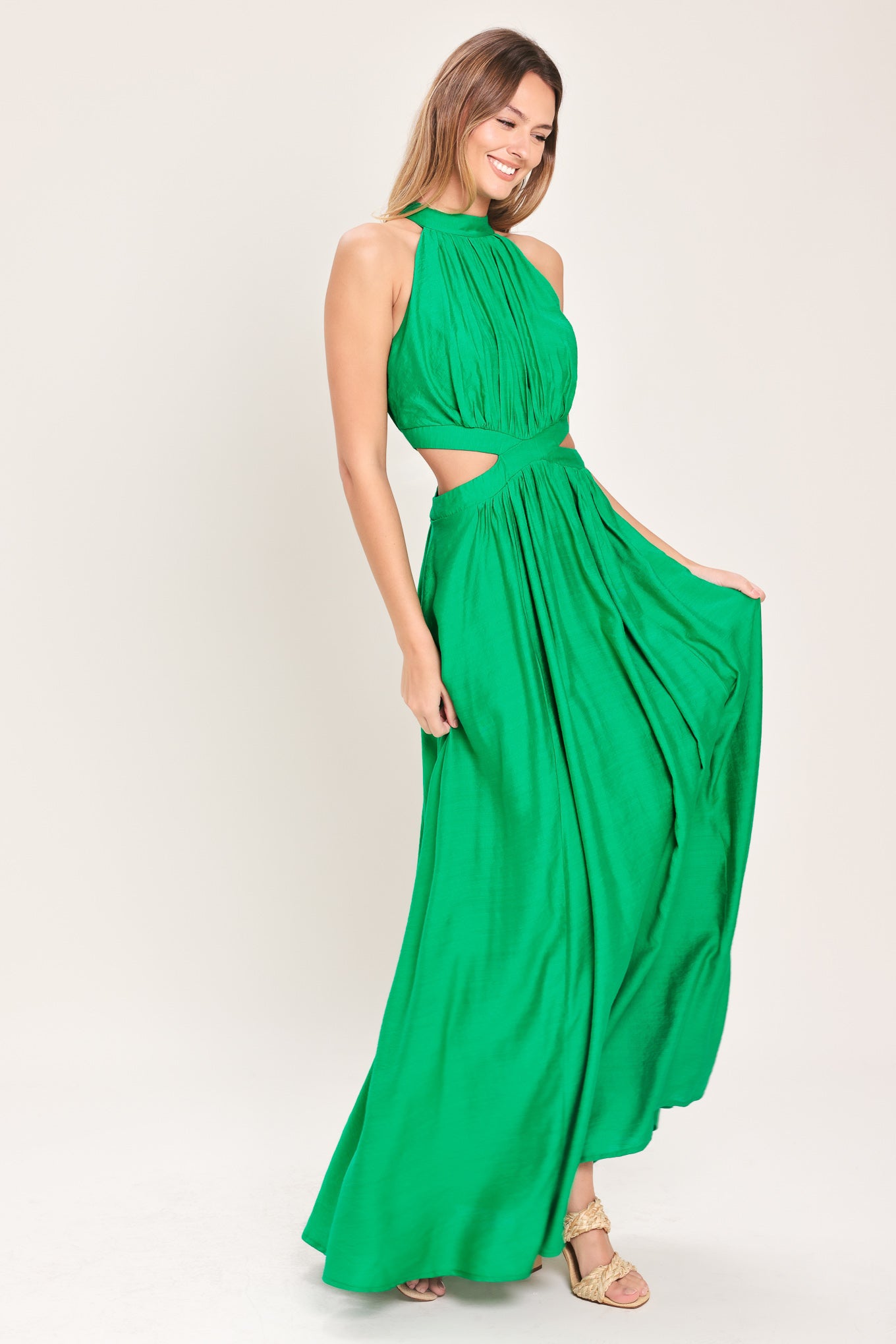 Woman wearing a green maxi dress featuring halter neckline, side cut out and back button/zipper closure | Flying Tomato