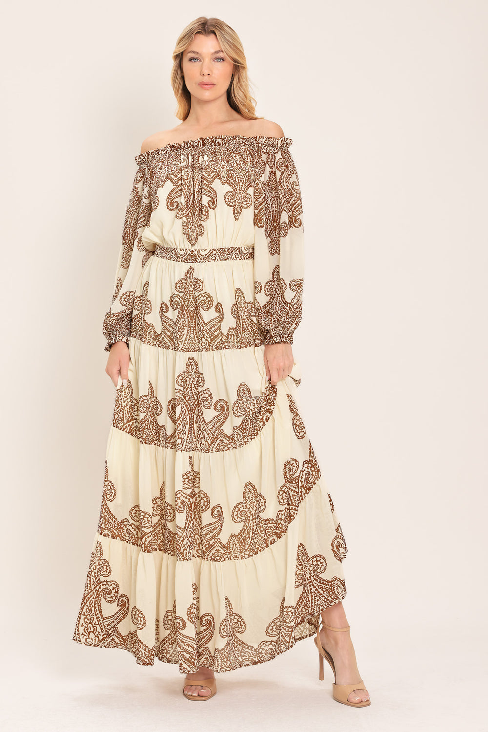 Woman wearing an off-shoulder maxi dress with intricate brown embroidery featuring a smocked back waistband | Flying Tomato