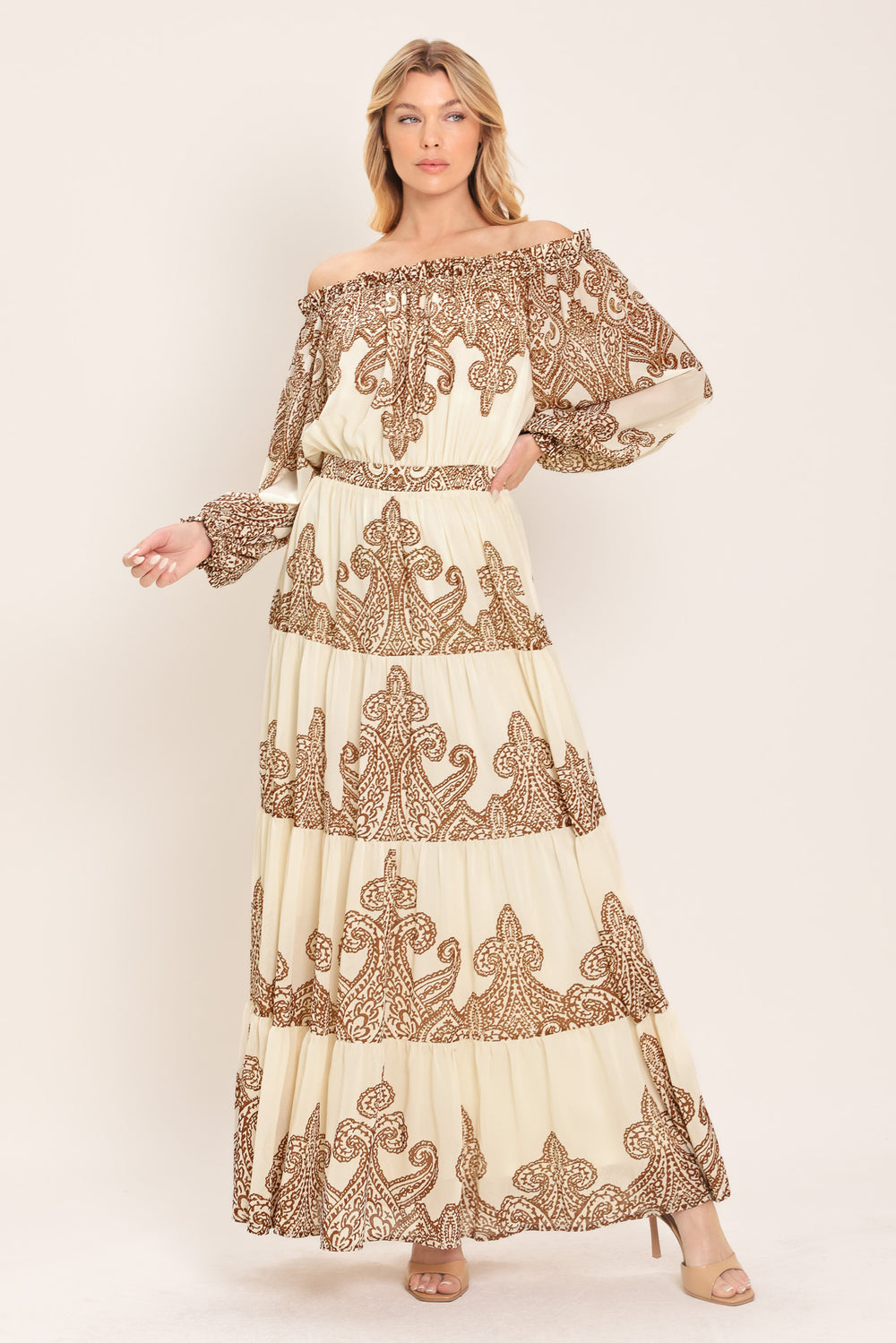 Woman wearing an off-shoulder maxi dress with intricate brown embroidery featuring a smocked back waistband | Flying Tomato