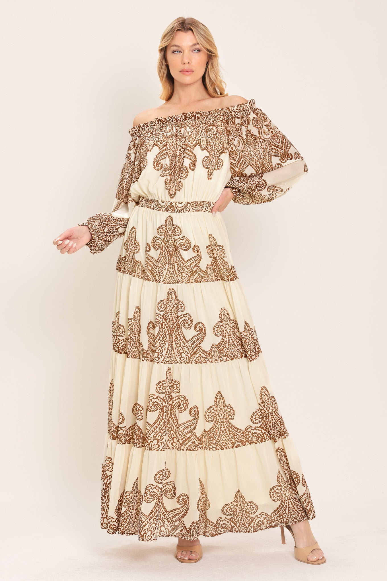 Woman wearing an off-shoulder maxi dress with intricate brown embroidery featuring a smocked back waistband | Flying Tomato