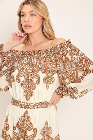 Woman wearing an off-shoulder maxi dress with intricate brown embroidery featuring a smocked back waistband | Flying Tomato
