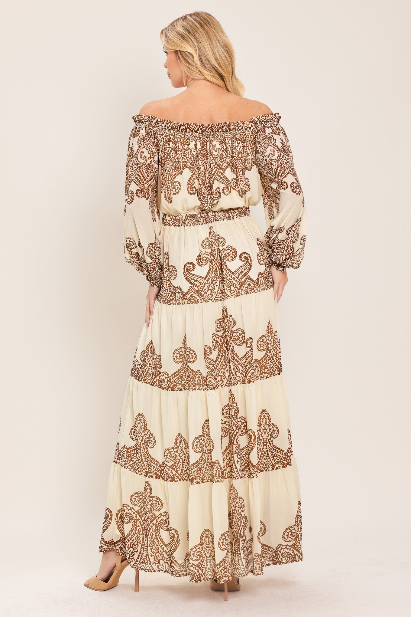 Woman wearing an off-shoulder maxi dress with intricate brown embroidery featuring a smocked back waistband | Flying Tomato
