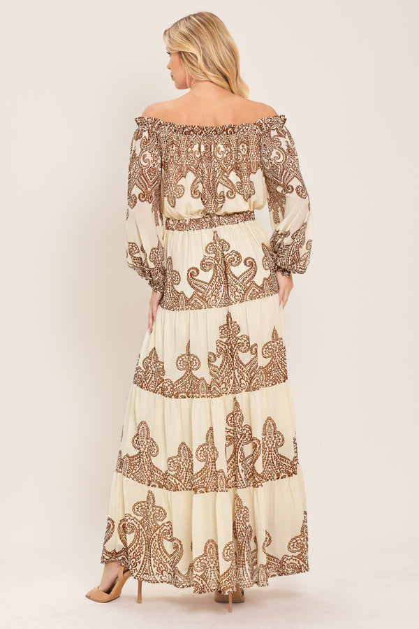 Woman wearing an off-shoulder maxi dress with intricate brown embroidery featuring a smocked back waistband | Flying Tomato