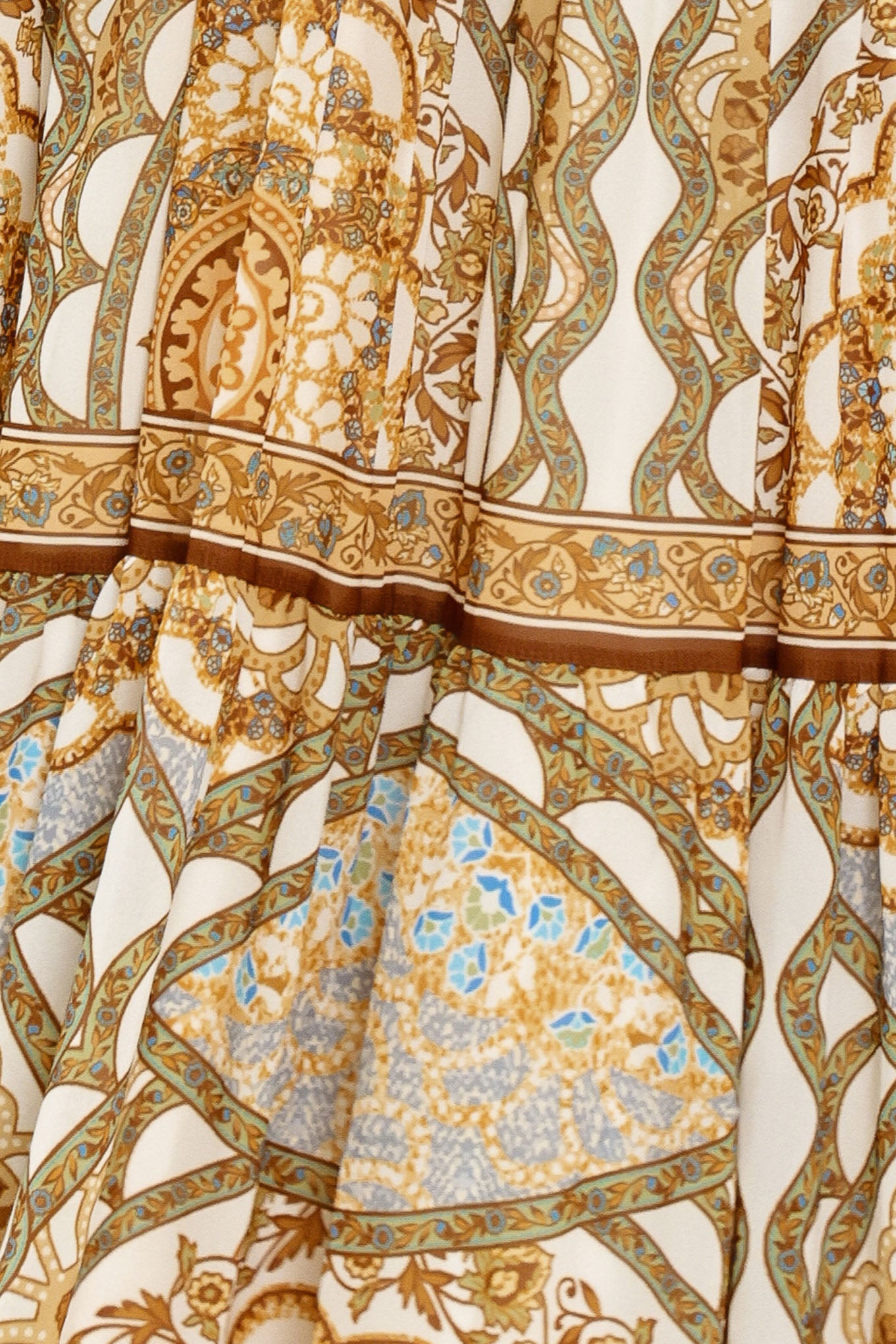 Close-up of intricate patterned fabric with gold, blue, and beige colors | Flying Tomato
