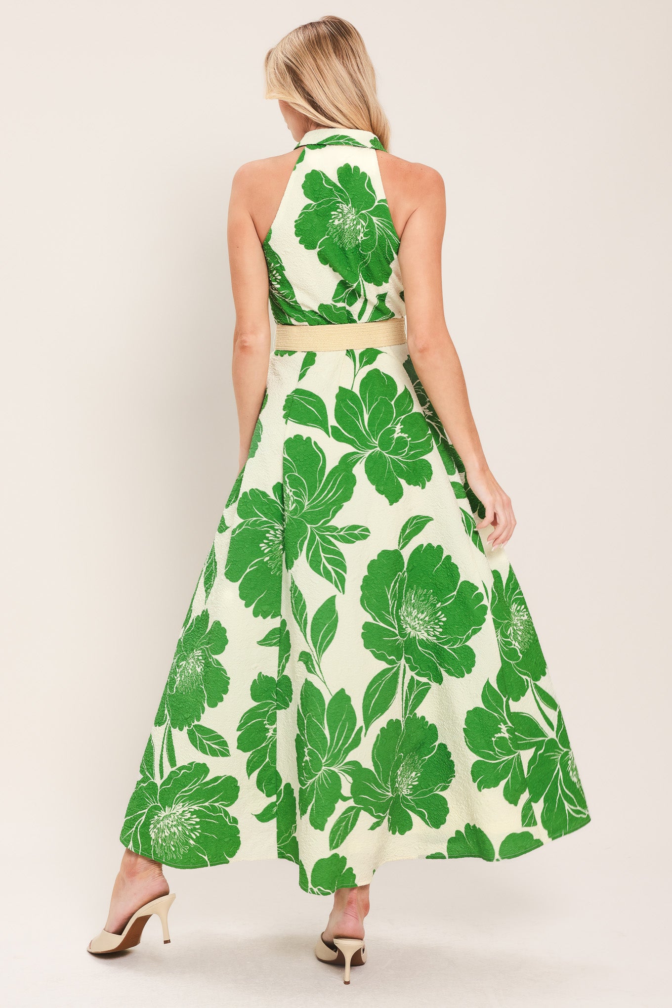 Woman wearing a sleeveless green floral midi dress featuring collar, front button down, contrasting belt and full skirt | Flying Tomato