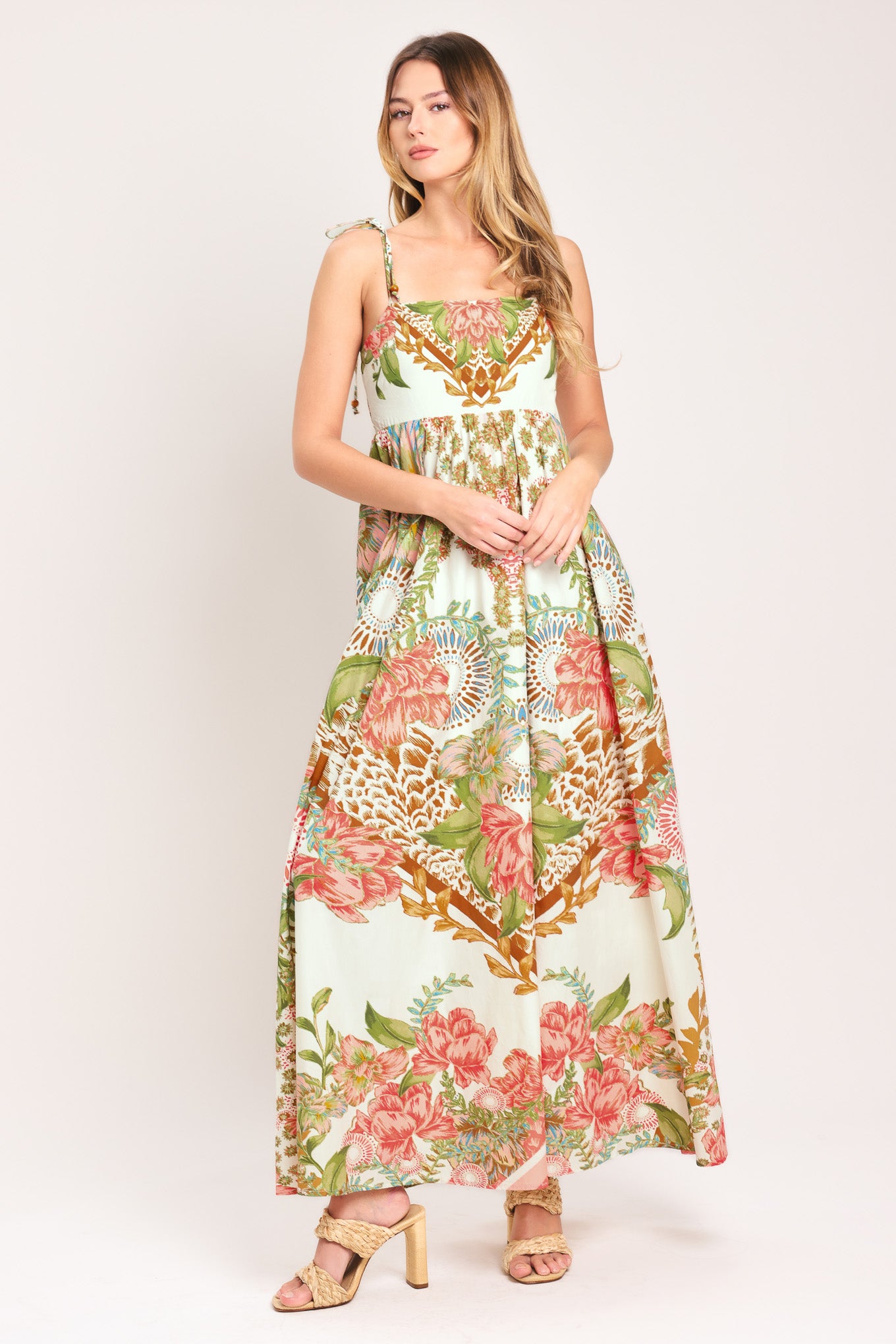 Woman wearing a floral ankle dress featuring straight neckline with shoulder tie, full skirt and smocked back bodice | Flying Tomato