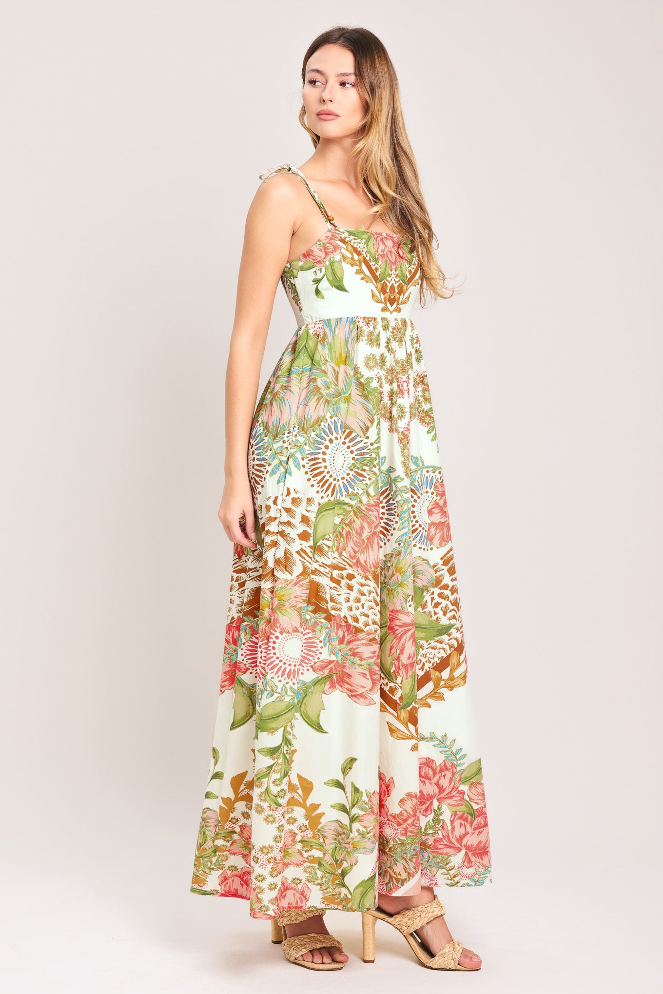 Woman wearing a floral ankle dress featuring straight neckline with shoulder tie, full skirt and smocked back bodice | Flying Tomato