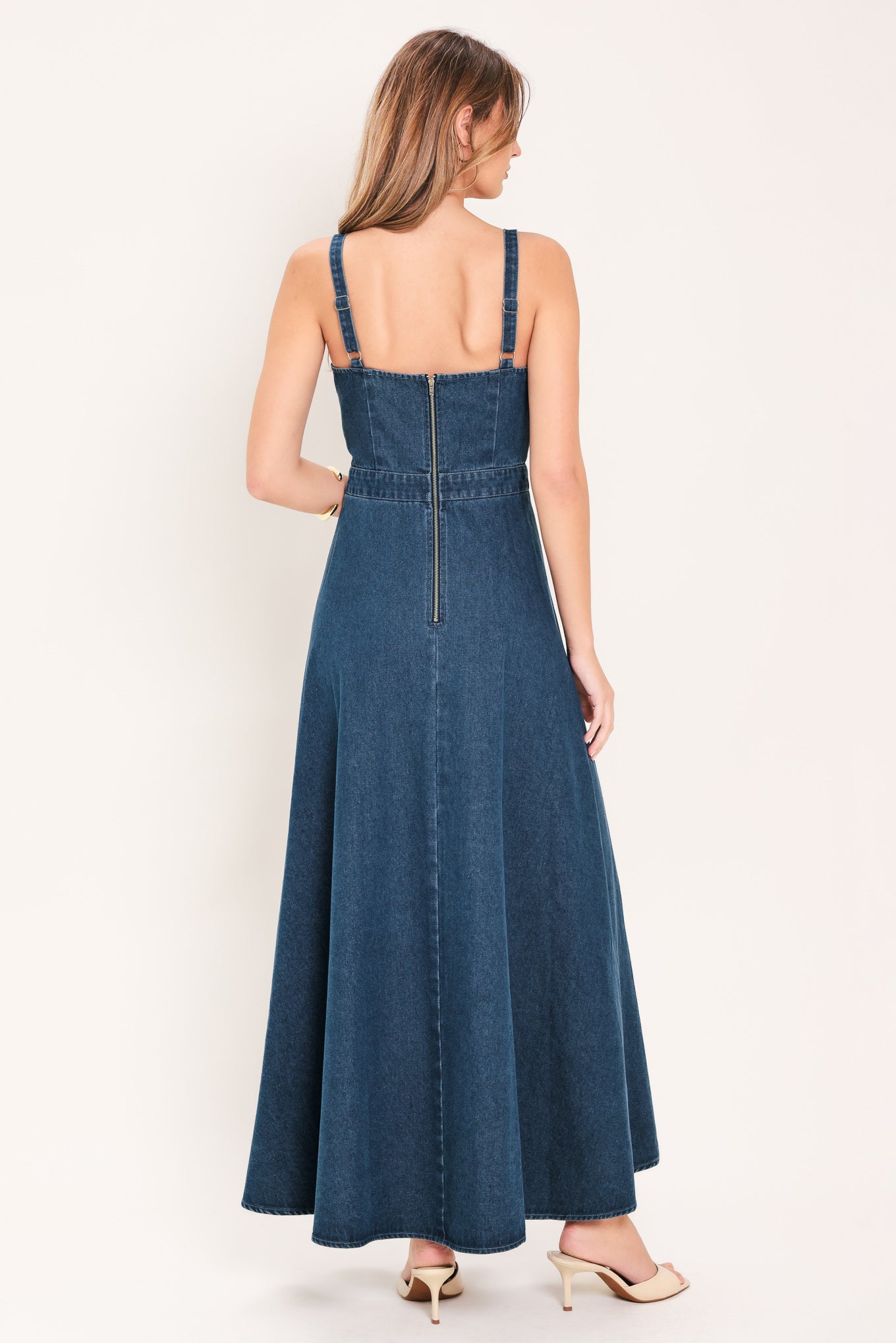 Woman wearing a blue denim midi dress with lilies printed featuring bustier top, straps, circle skirt and back zipper closure | Flying Tomato