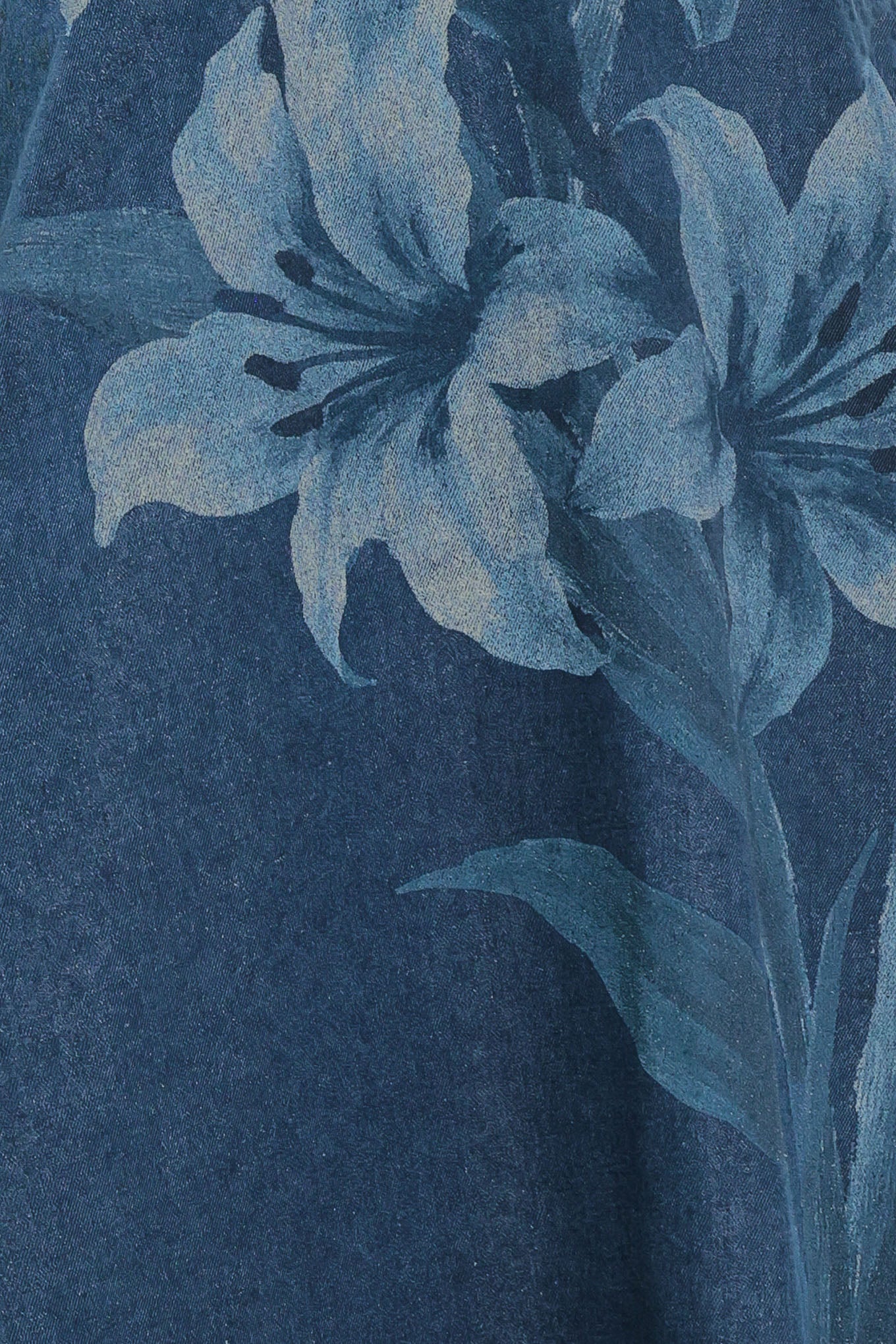 Close-up of blue floral pattern on a textured blue denim fabric