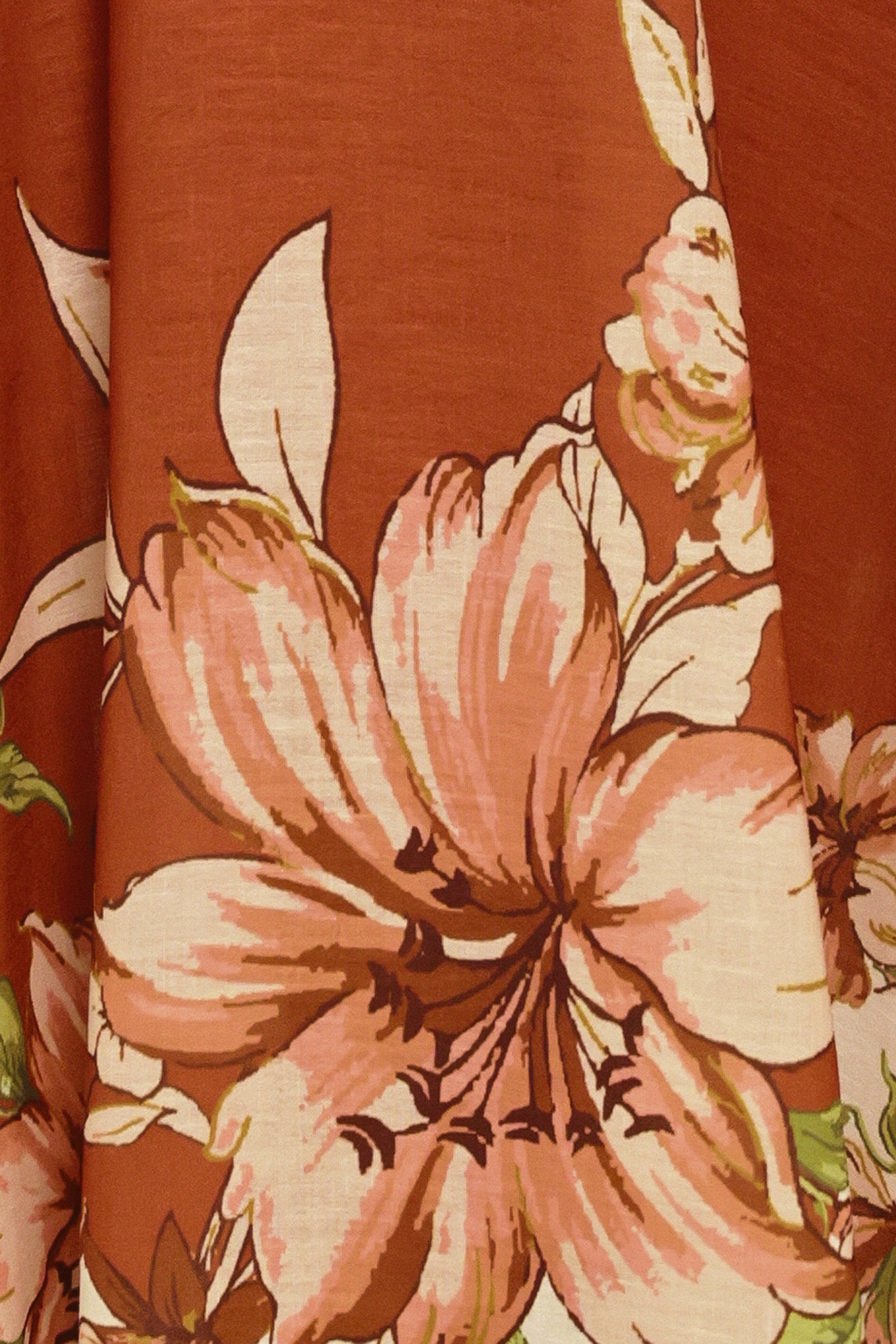 Woman wearing a terracotta midi dress with floral print on the top and bottom, featuring straight neckline, straps, circle skirt and back zipper closure | Flying Tomato