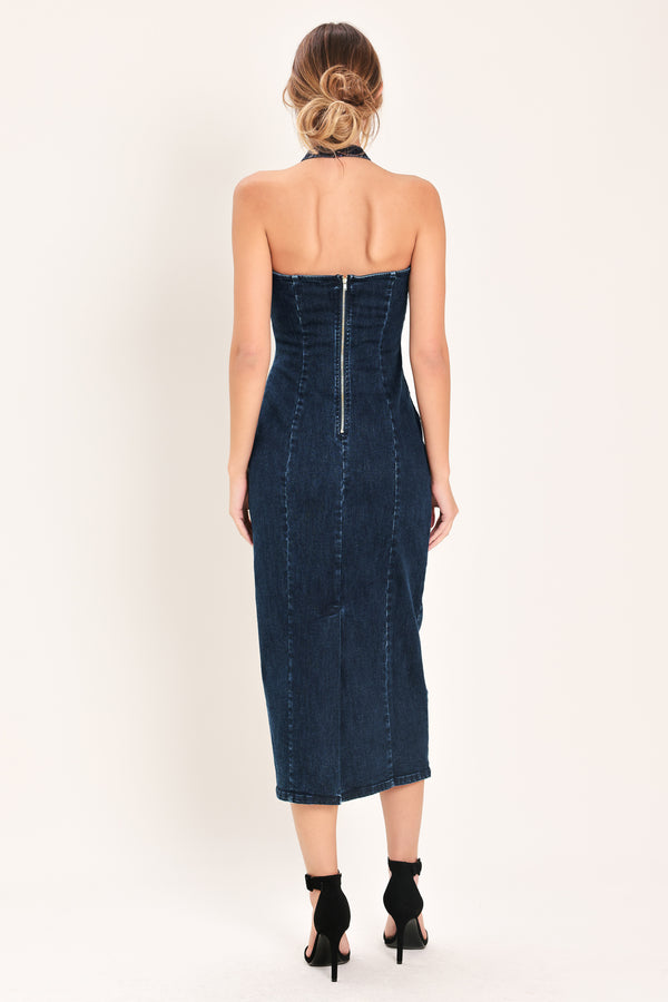 Woman wearing a dark indigo denim midi dress featuring halter neckline with hardware, bare back and zipper closure | Flying Tomato