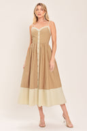 Woman wearing a beige color blocked midi dress featuring sweetheart neckline, straps, button down detail and smocked back bodice | Flying Tomato