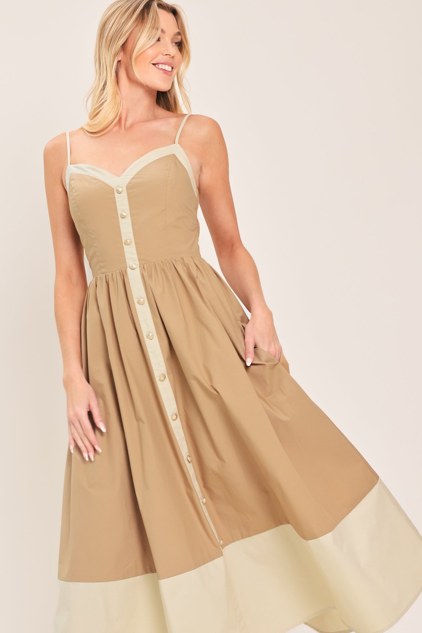 Woman wearing a beige color blocked midi dress featuring sweetheart neckline, straps, button down detail and smocked back bodice | Flying Tomato