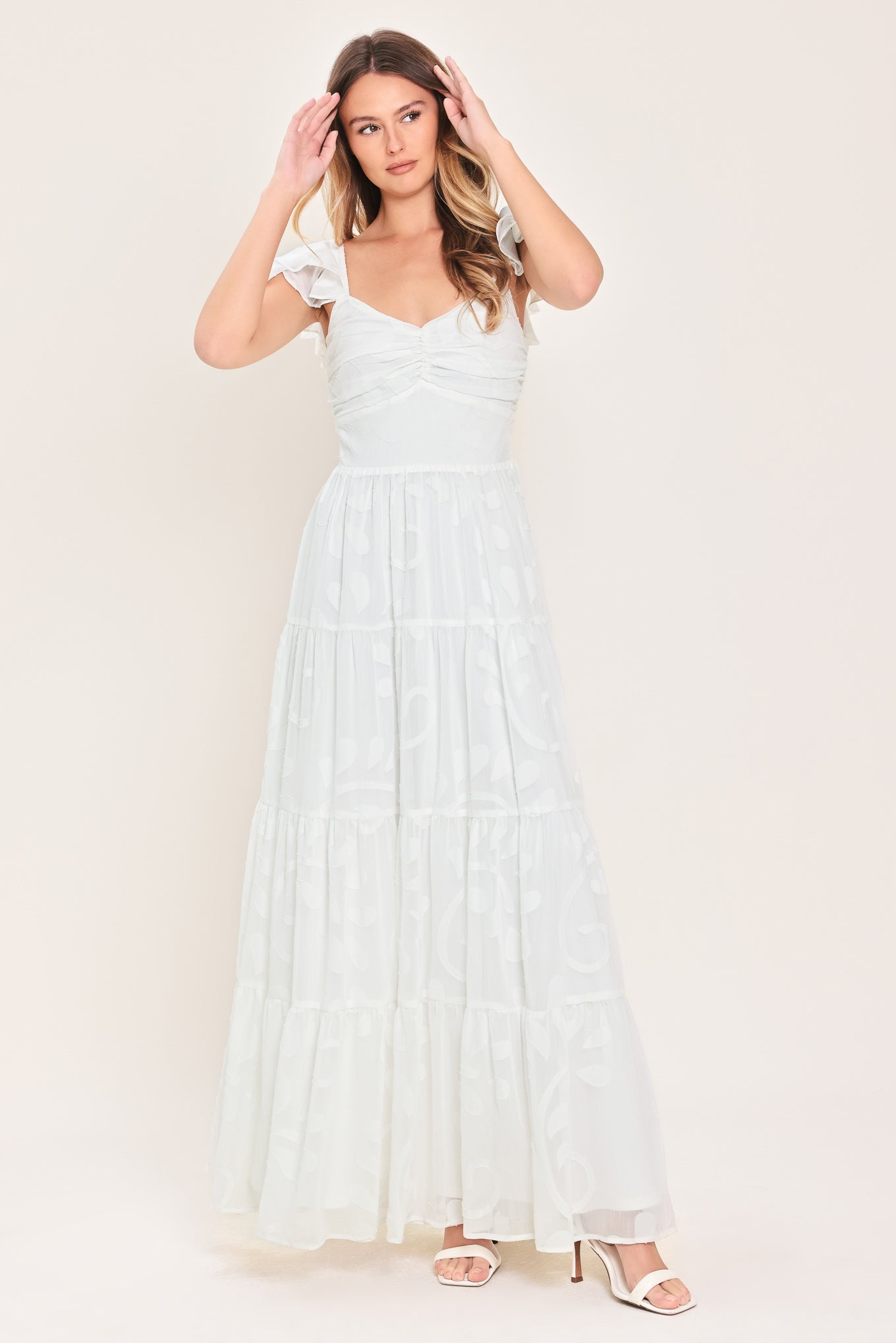 Woman wearing a white maxi dress featuring sweetheart neckline, ruffle sleeve, tier skirt and smocked back bodice  | FREEMARKET