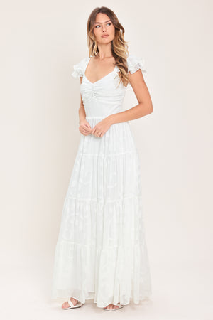Woman wearing a white maxi dress featuring sweetheart neckline, ruffle sleeve, tier skirt and smocked back bodice  | FREEMARKET