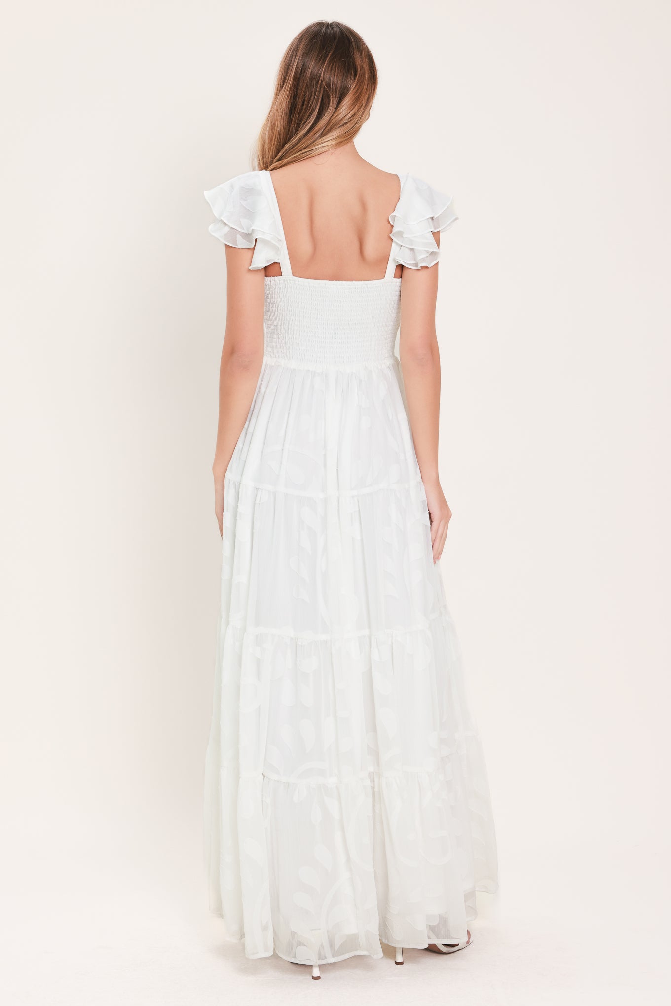 Woman wearing a white maxi dress featuring sweetheart neckline, ruffle sleeve, tier skirt and smocked back bodice  | FREEMARKET