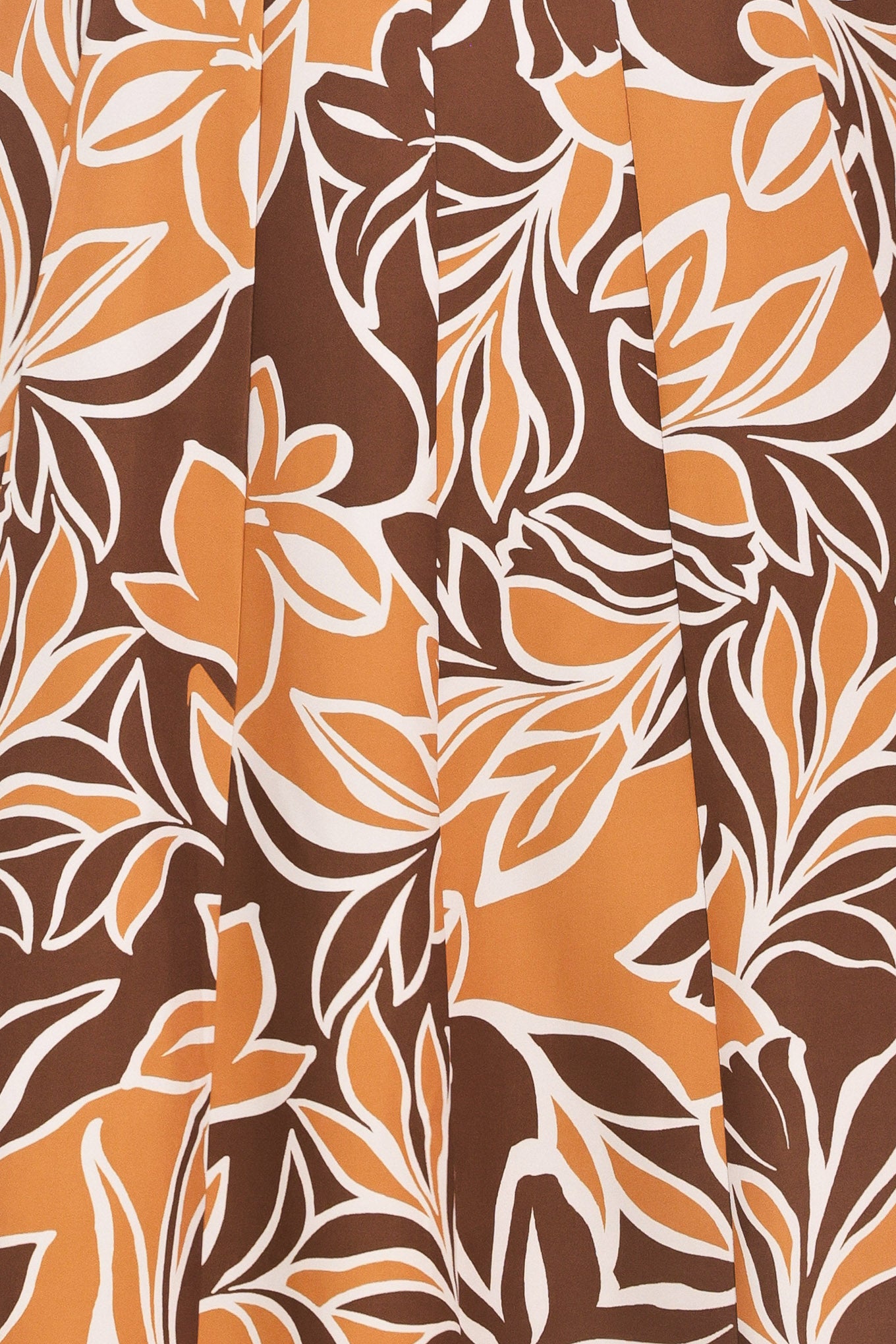 A woman modeling a sleeveless, floor-length maxi dress with a bold brown, tan, and white tropical floral pattern | Flying Tomato