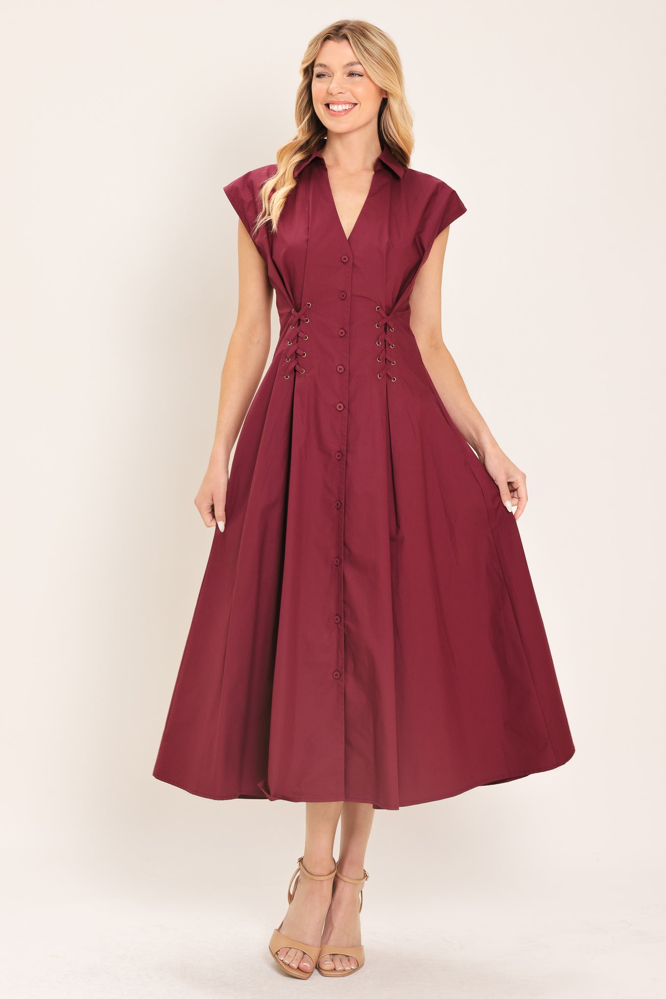 Woman wearing a burgundy midi dress featuring V neckline with collared finish, short sleeve, lace up corset waist and front button down | Flying Tomato