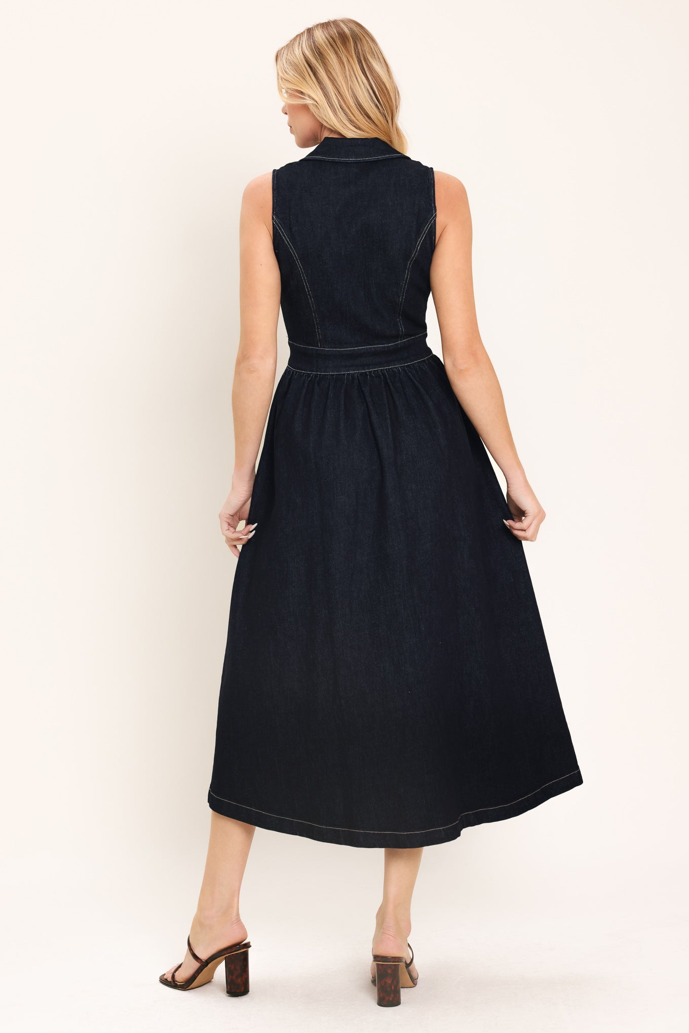 Woman wearing a black sleeveless dark denim midi dress featuring collar, sleeveless, button down and full skirt | Flying Tomato