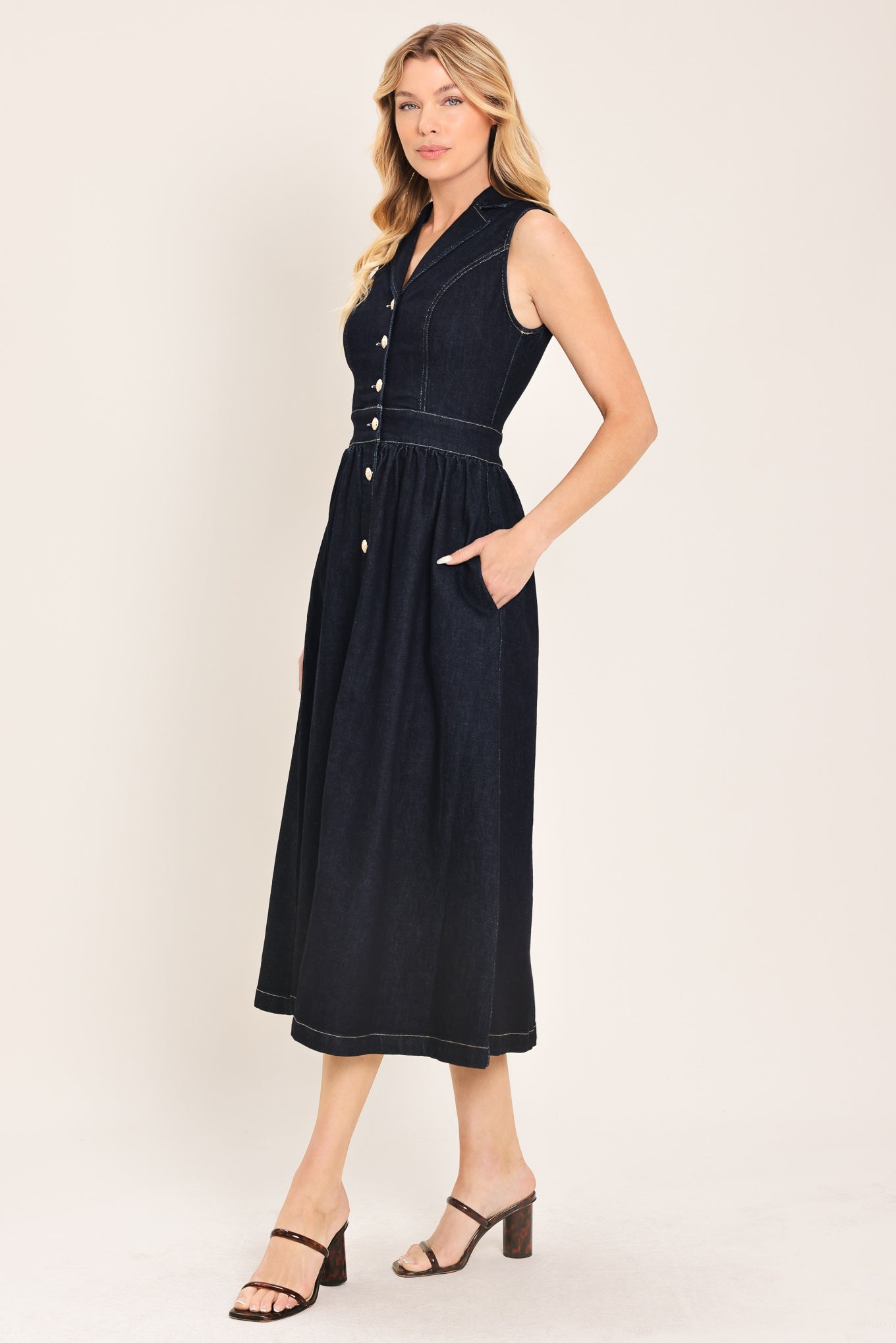 Woman wearing a black sleeveless dark denim midi dress featuring collar, sleeveless, button down and full skirt | Flying Tomato