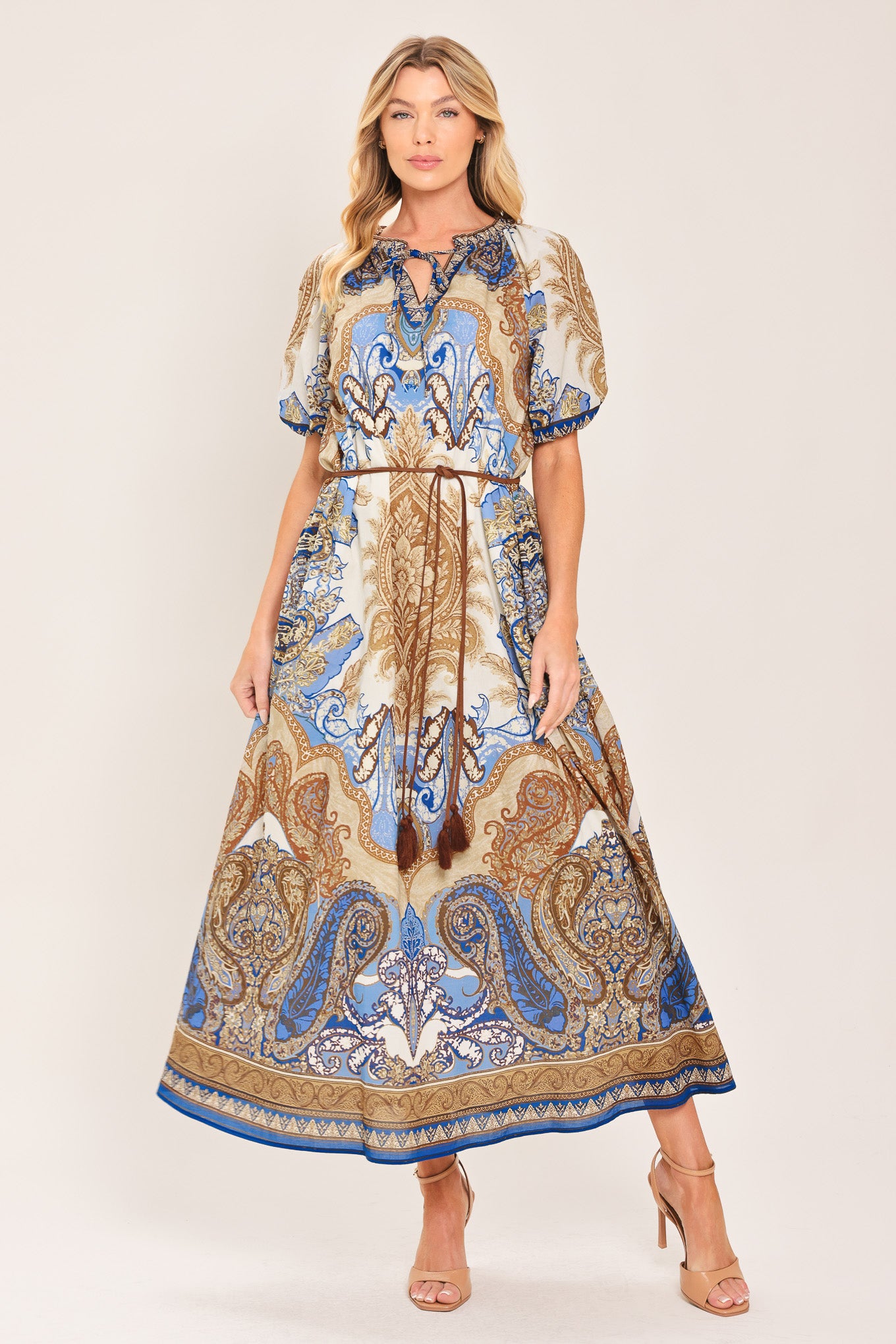 Woman wearing a navy blue pattered  printed woven midi dress featuring round neckline with ruffle edge and tie, short puff sleeve and contrasting belt with tassel | Flying Tomato