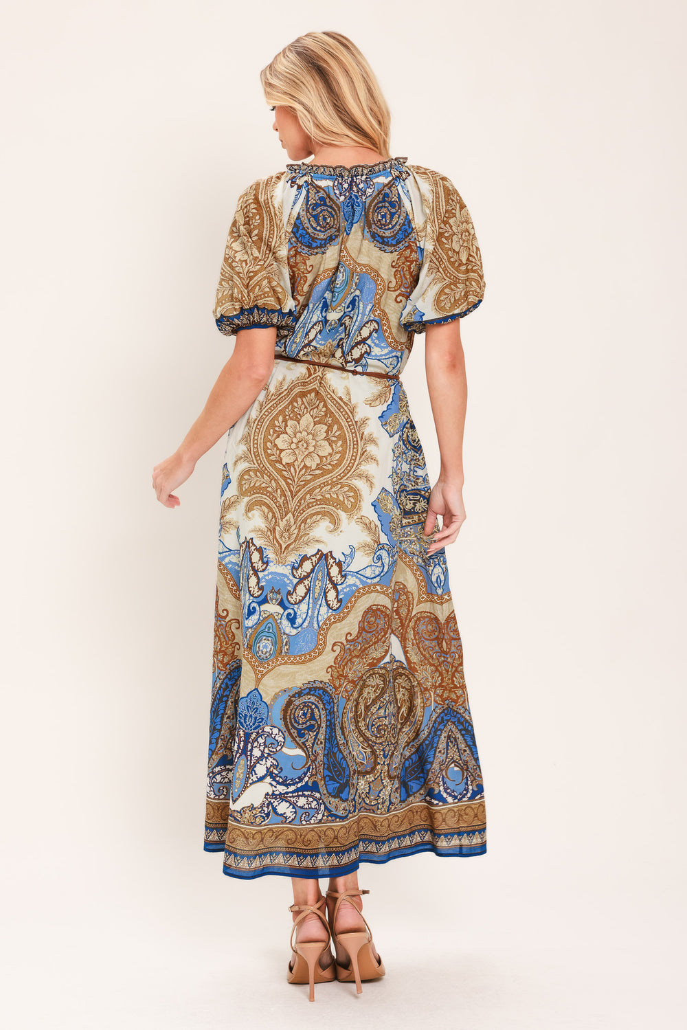 Woman wearing a navy blue pattered  printed woven midi dress featuring round neckline with ruffle edge and tie, short puff sleeve and contrasting belt with tassel | Flying Tomato