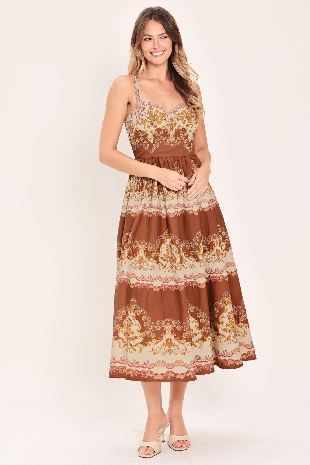 Woman wearing a brown floral midi dress featuring bustier top, straps, full skirt and smocked back bodice | Flying Tomato