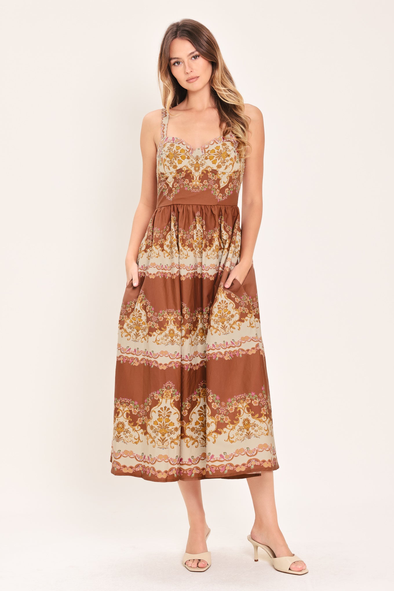 Woman wearing a brown floral midi dress featuring bustier top, straps, full skirt and smocked back bodice | Flying Tomato