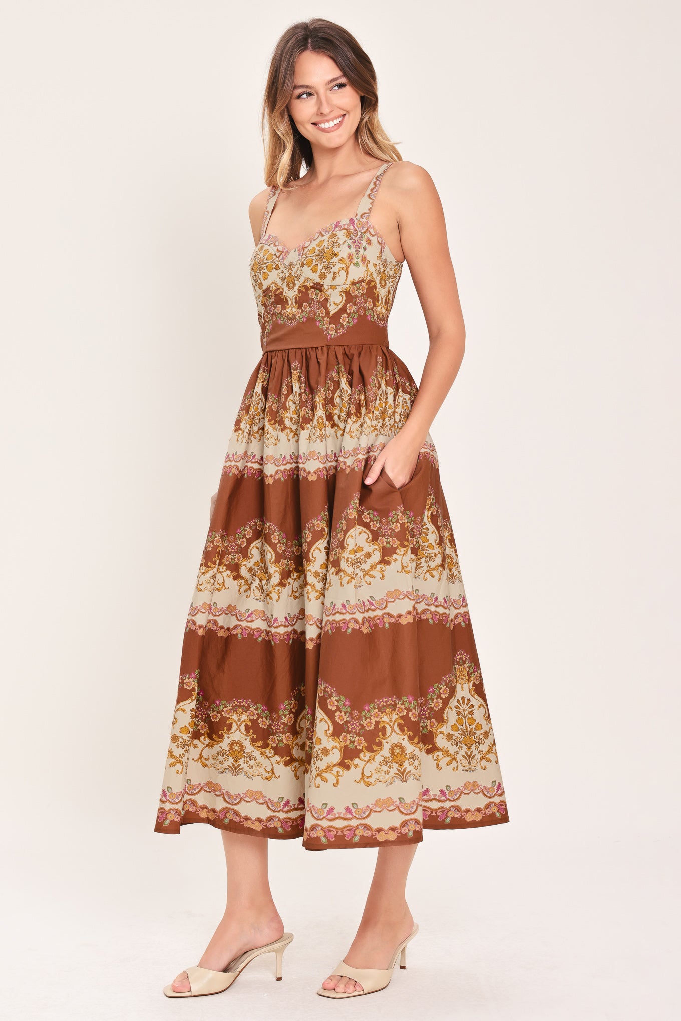 Woman wearing a brown floral midi dress featuring bustier top, straps, full skirt and smocked back bodice | Flying Tomato