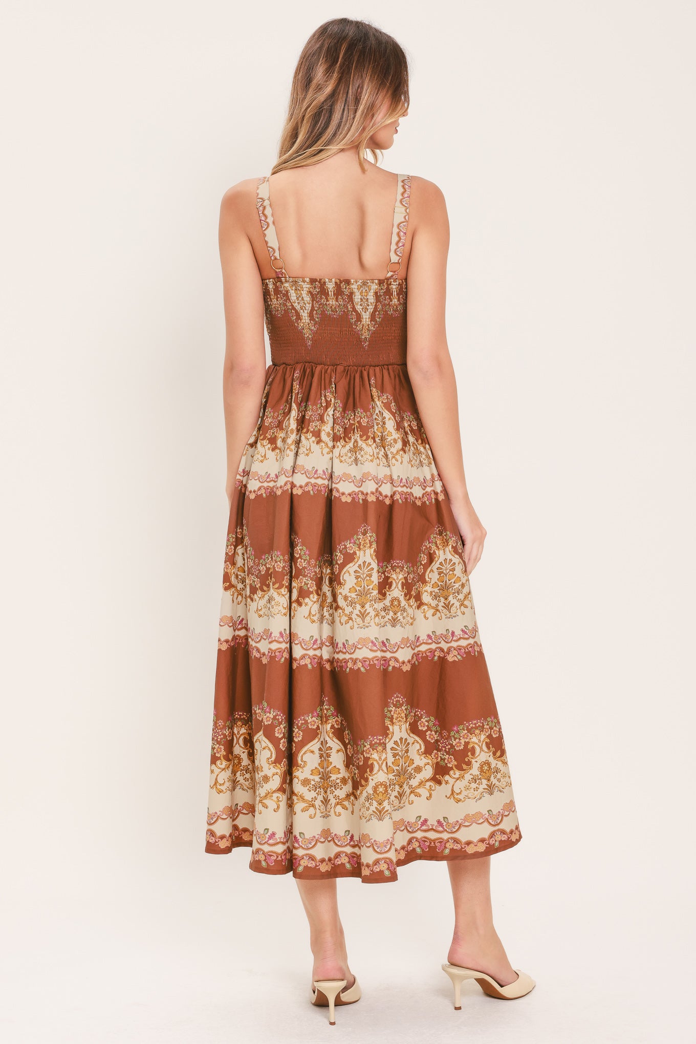 Woman wearing a brown floral midi dress featuring bustier top, straps, full skirt and smocked back bodice | Flying Tomato
