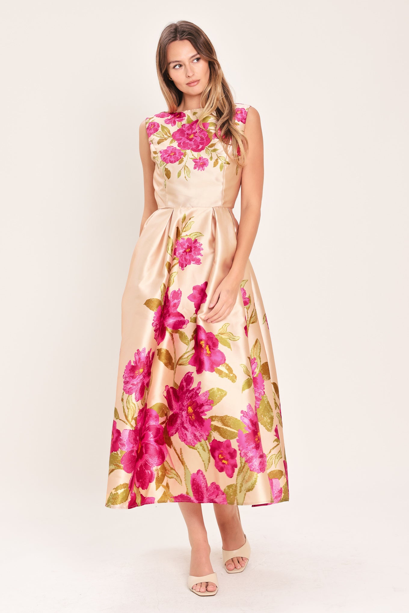 Woman wearing a sleeveless pink floral midi dress featuring wide neckline, full skirt, back cut out and zipper closure | Flying Tomato