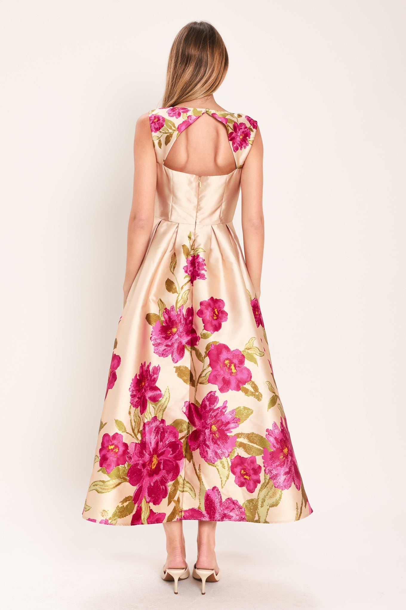 Woman wearing a sleeveless pink floral midi dress featuring wide neckline, full skirt, back cut out and zipper closure | Flying Tomato