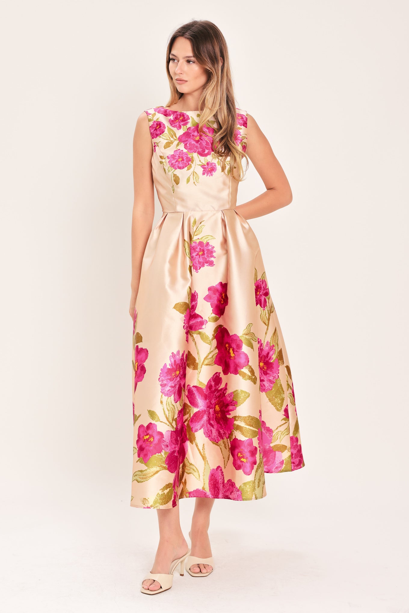 Woman wearing a sleeveless pink floral midi dress featuring wide neckline, full skirt, back cut out and zipper closure | Flying Tomato