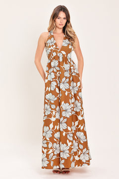 Woman wearing a camel and white with black lineart floral maxi dress maxi dress featuring halter neckline with back neck tie, bare back and smocked bodice | Flying Tomato