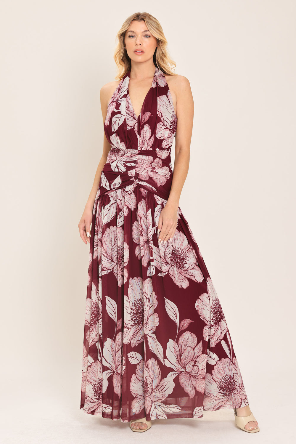 Woman wearing a burgundy floral power mesh maxi dress featuring V halter neckline, shirred mid- drift, bare back and zipper closure | Flying Tomato