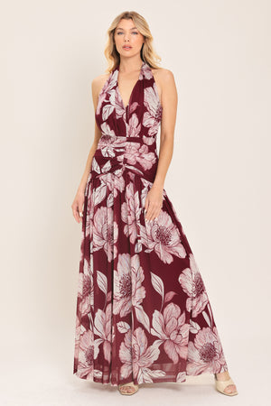 Woman wearing a burgundy floral power mesh maxi dress featuring V halter neckline, shirred mid- drift, bare back and zipper closure | Flying Tomato