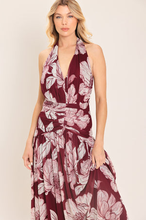 Woman wearing a burgundy floral power mesh maxi dress featuring V halter neckline, shirred mid- drift, bare back and zipper closure | Flying Tomato