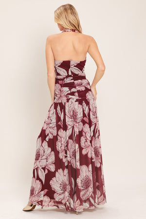 Woman wearing a burgundy floral power mesh maxi dress featuring V halter neckline, shirred mid- drift, bare back and zipper closure | Flying Tomato
