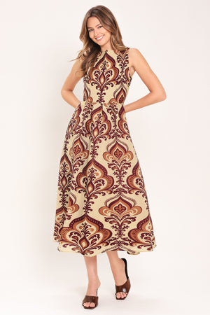 Woman wearing a taupe patterned  midi dress featuring round neckline, sleeveless, full skirt and back zipper closure | Flying Tomato