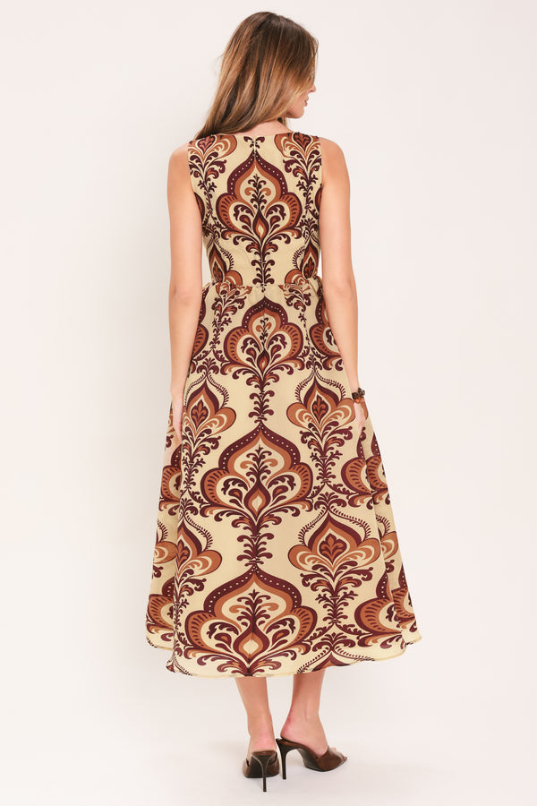 Woman wearing a taupe patterned  midi dress featuring round neckline, sleeveless, full skirt and back zipper closure | Flying Tomato