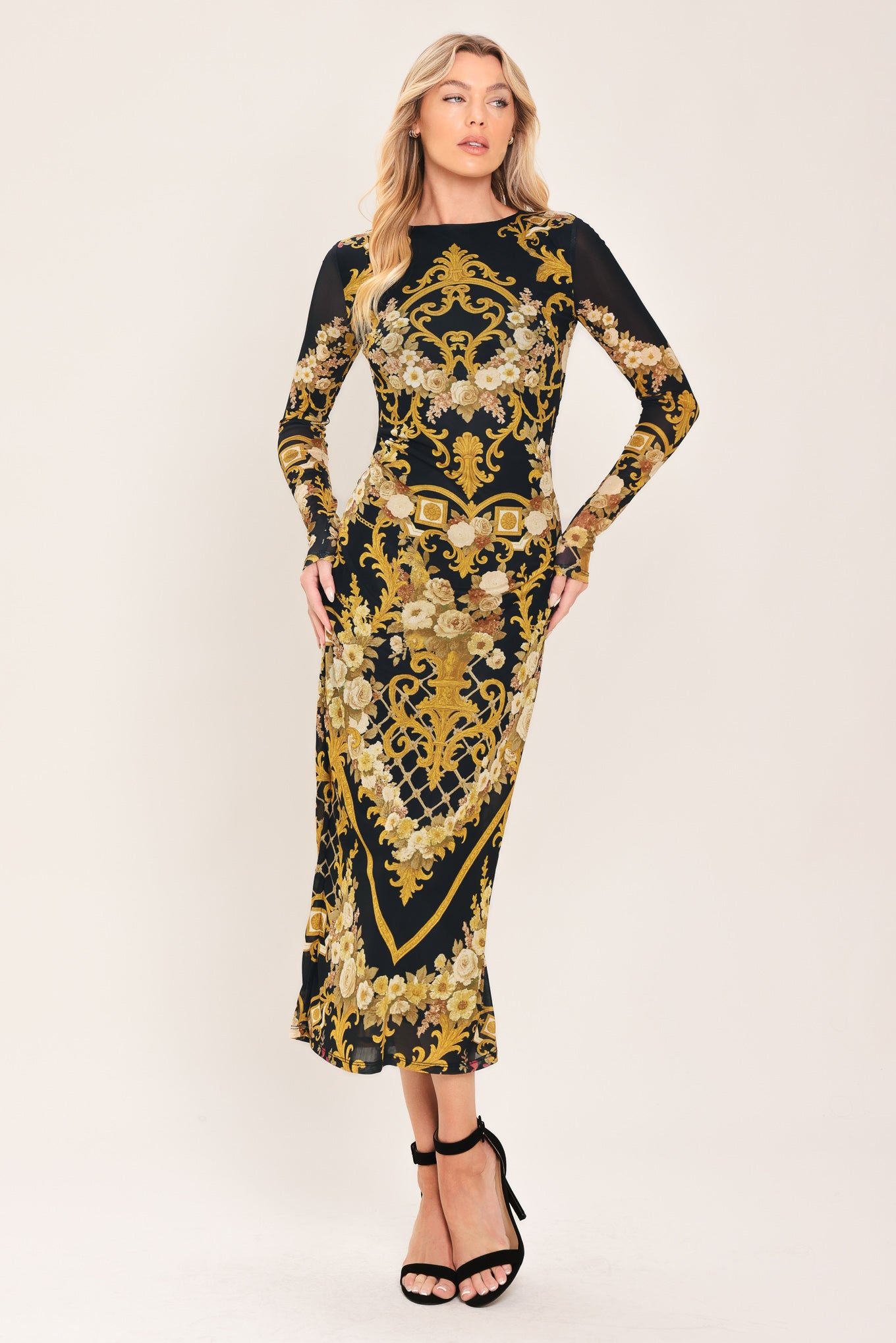 Woman wearing a black and gold baroque printed power mesh midi dress with long sleeve and back neck button | Flying Tomato