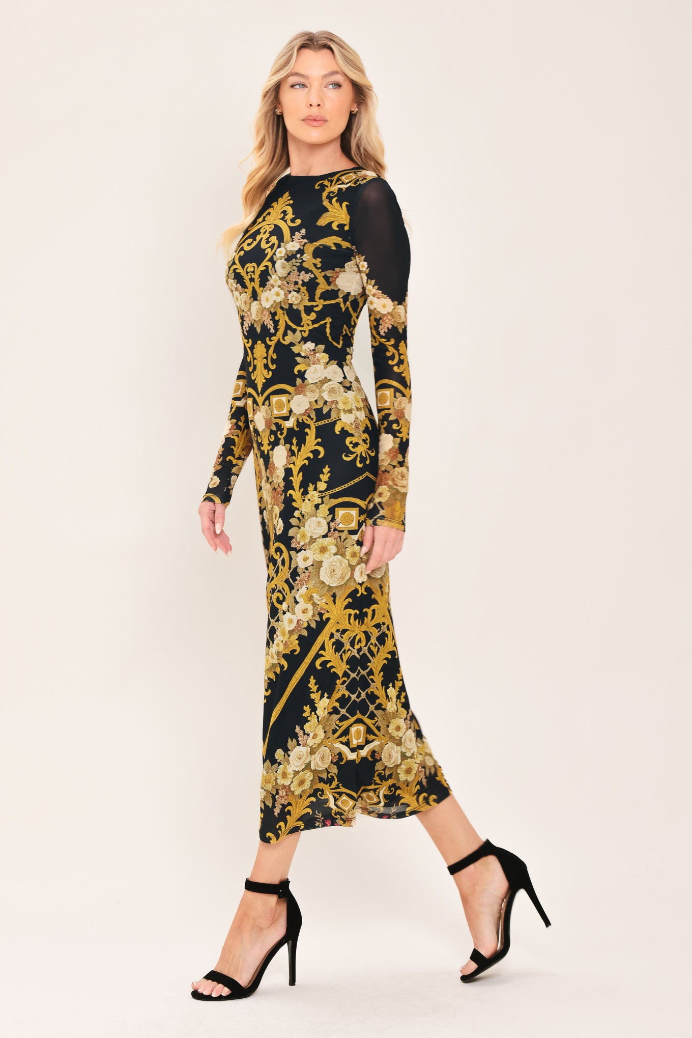 Woman wearing a black and gold baroque printed power mesh midi dress with long sleeve and back neck button | Flying Tomato