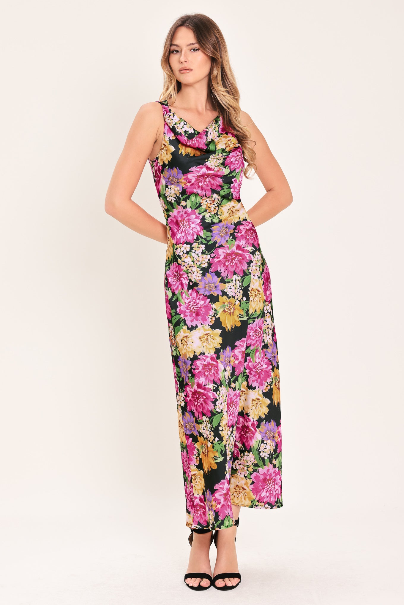 Woman wearing a multicolor pink, yellow, and green floral midi dress with cowl neck and side zipper closure | Flying Tomato