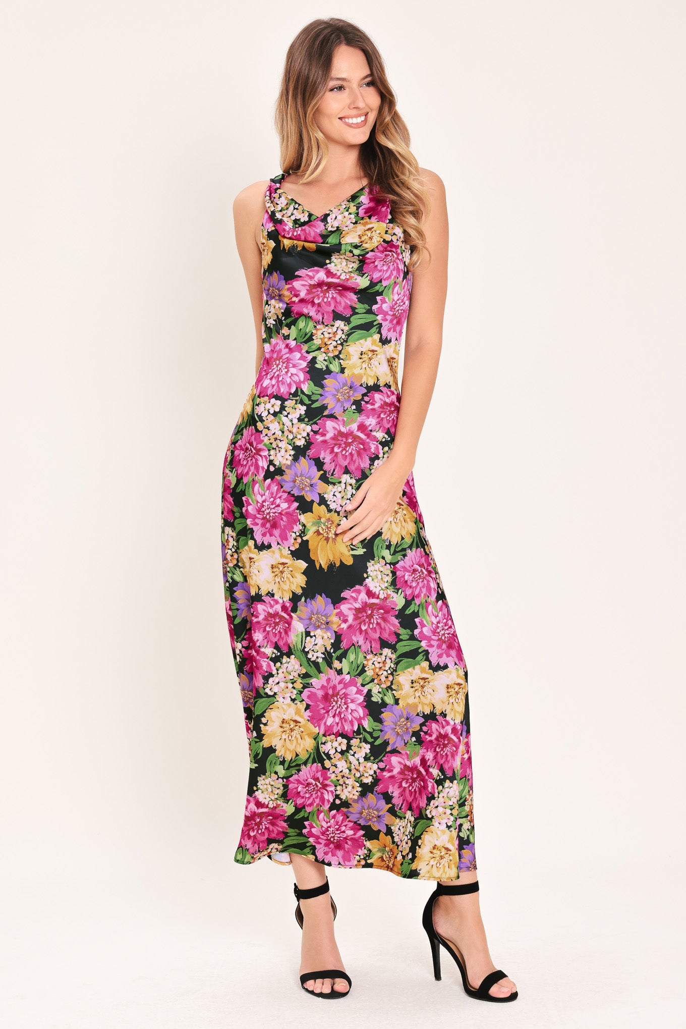 Woman wearing a multicolor pink, yellow, and green floral midi dress with cowl neck and side zipper closure | Flying Tomato