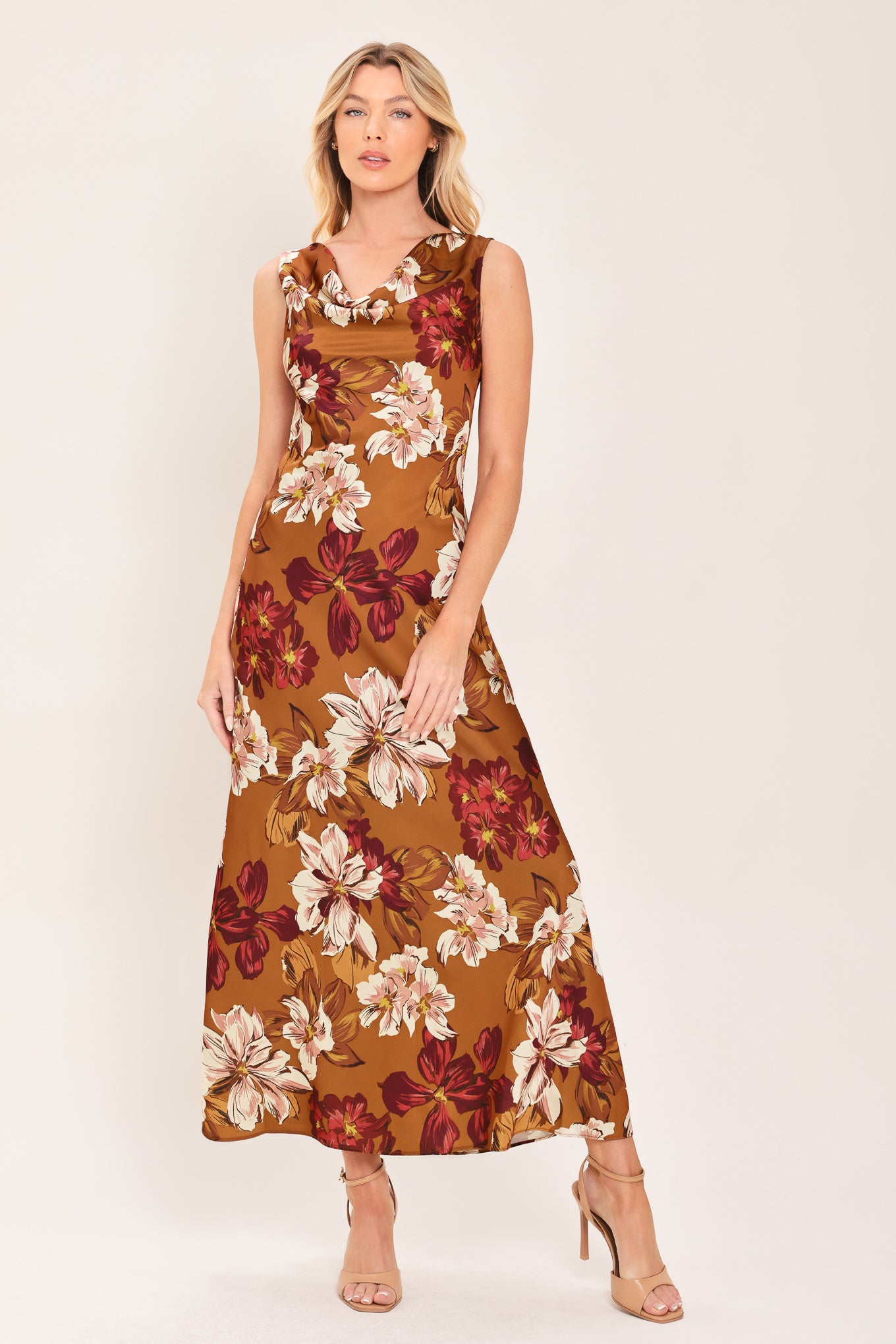 Woman wearing a caramel colored with floral printed woven midi dress featuring cowl neckline, sleeveless, circle skirt and twisted strap at back | Flying Tomato