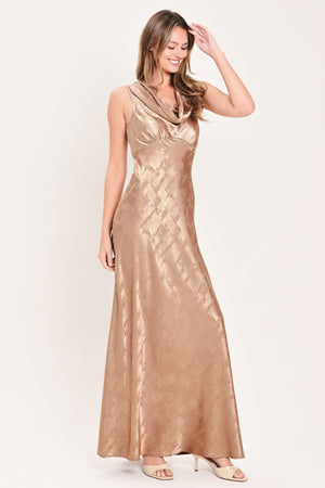 A woman wearing a sleeveless, floor-length metallic champagne-gold gown with a draped neckline and a subtle crinkle texture | Flying Tomato