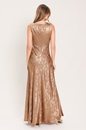 A woman wearing a sleeveless, floor-length metallic champagne-gold gown with a draped neckline and a subtle crinkle texture | Flying Tomato