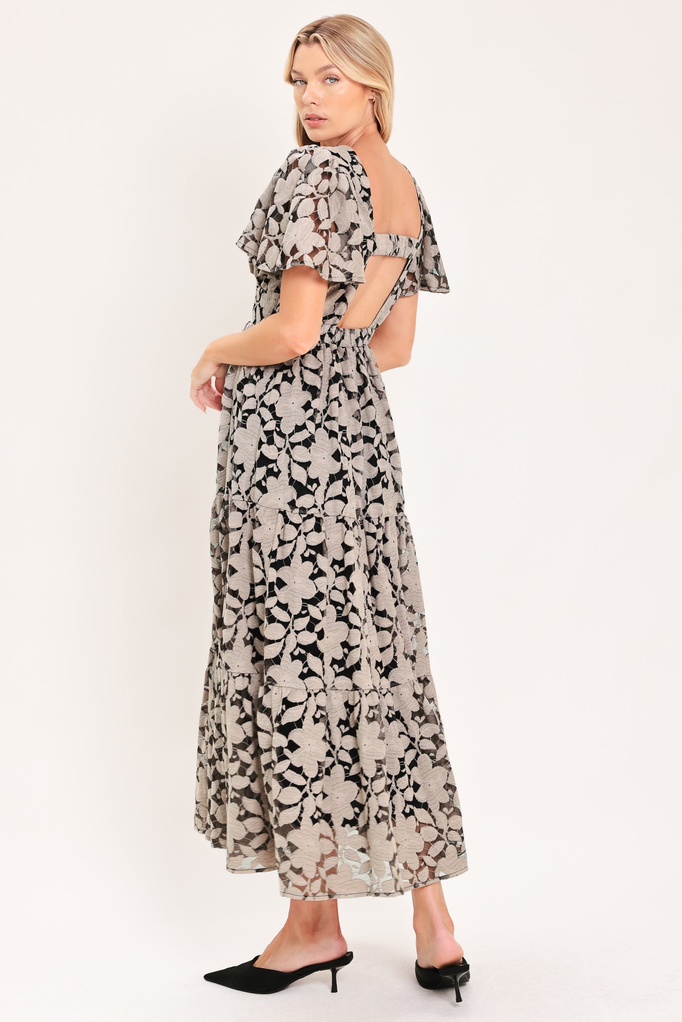 A woman modeling a long-sleeved midi dress with a black and taupe abstract floral pattern | Flying Tomato