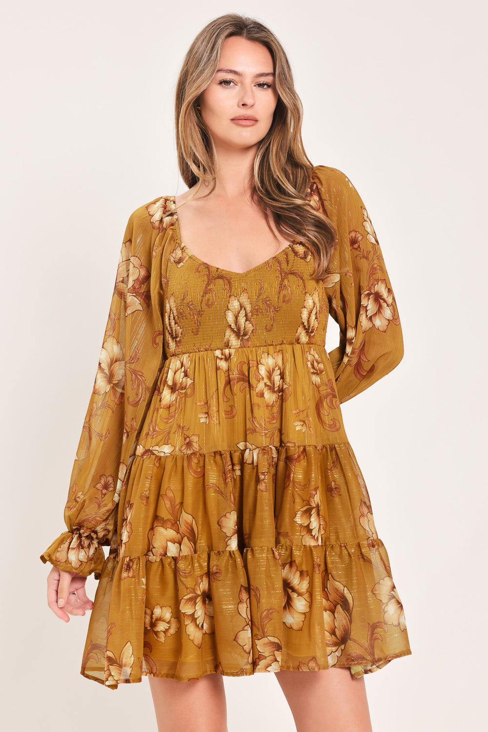 A woman modeling a mustard yellow mini dress with a beige floral pattern, long balloon sleeves, and a V-neckline | FREEMARKET