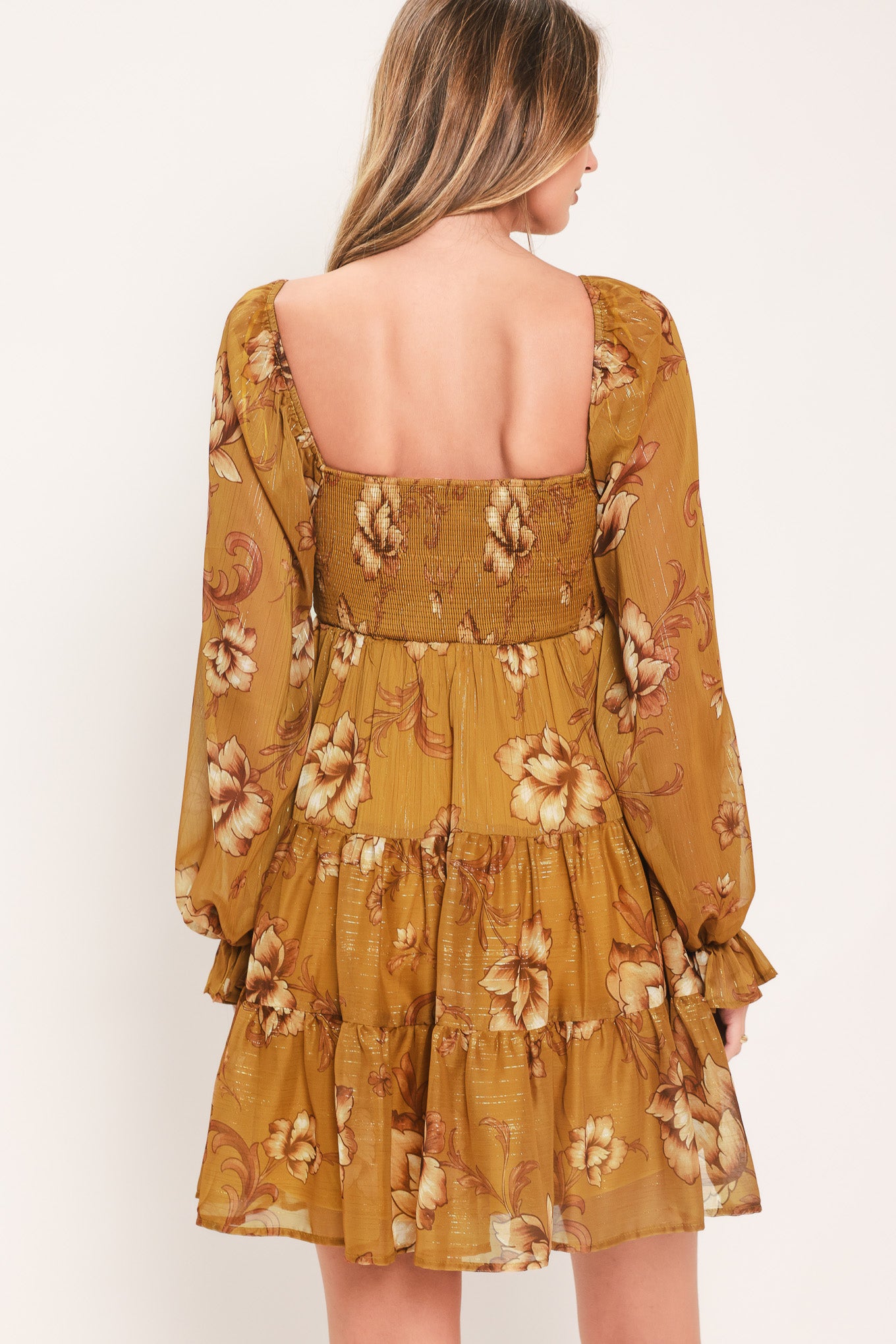 A woman modeling a mustard yellow mini dress with a beige floral pattern, long balloon sleeves, and a V-neckline | FREEMARKET